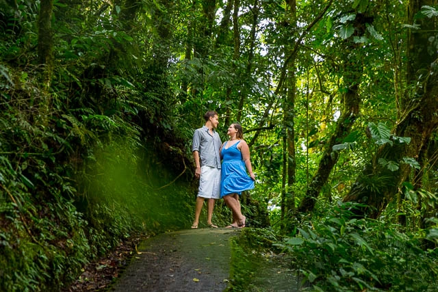 alt="Couple on a scenic nature walk through a lush green jungle trail in Costa Rica